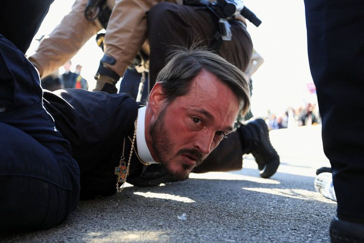 Faith leader, Michael Woolf, minister at Lake Street Church of Evanston, is detained by Illinois State Police during a protest against immigration actions, outside the Broadview ICE facility in Chicago, Illinois, U.S., November 14, 2025. REUTERS/Jim Vondruska (Jim Vondruska)