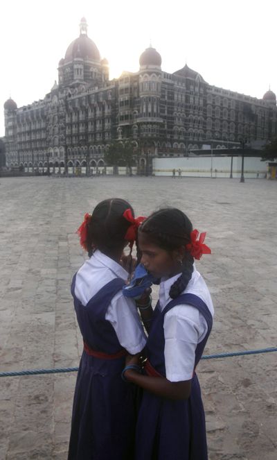 Two schoolgirls react Saturday after seeing the Taj Mahal hotel, a target of last month’s militant attacks in Mumbai, India. The sole captured gunman has written to Pakistani officials seeking legal help.  (Associated Press / The Spokesman-Review)
