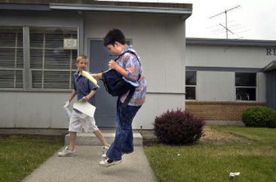 Ridgeview Elementary School fifth-grader Tyler Ernst leaps as he sees all B's on his final report card on the last day of school Thursday in Spokane.
(Brian Plonka / The Spokesman-Review)