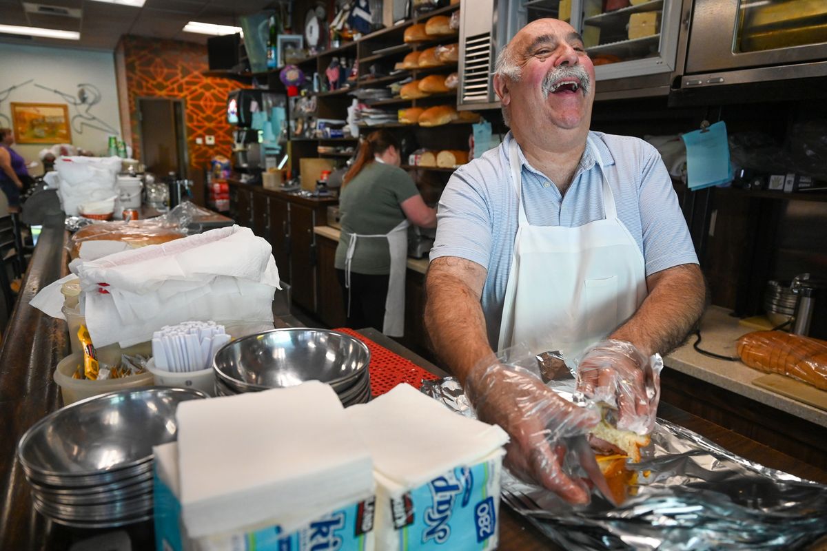 Tom Domini, owner of Domini’s Sandwiches, wraps up an order Friday while chatting with customers. The sandwich shop has been in downtown Spokane for more than 60 years. He will close it on Dec. 6.  (Jesse Tinsley/The Spokesman-Review)