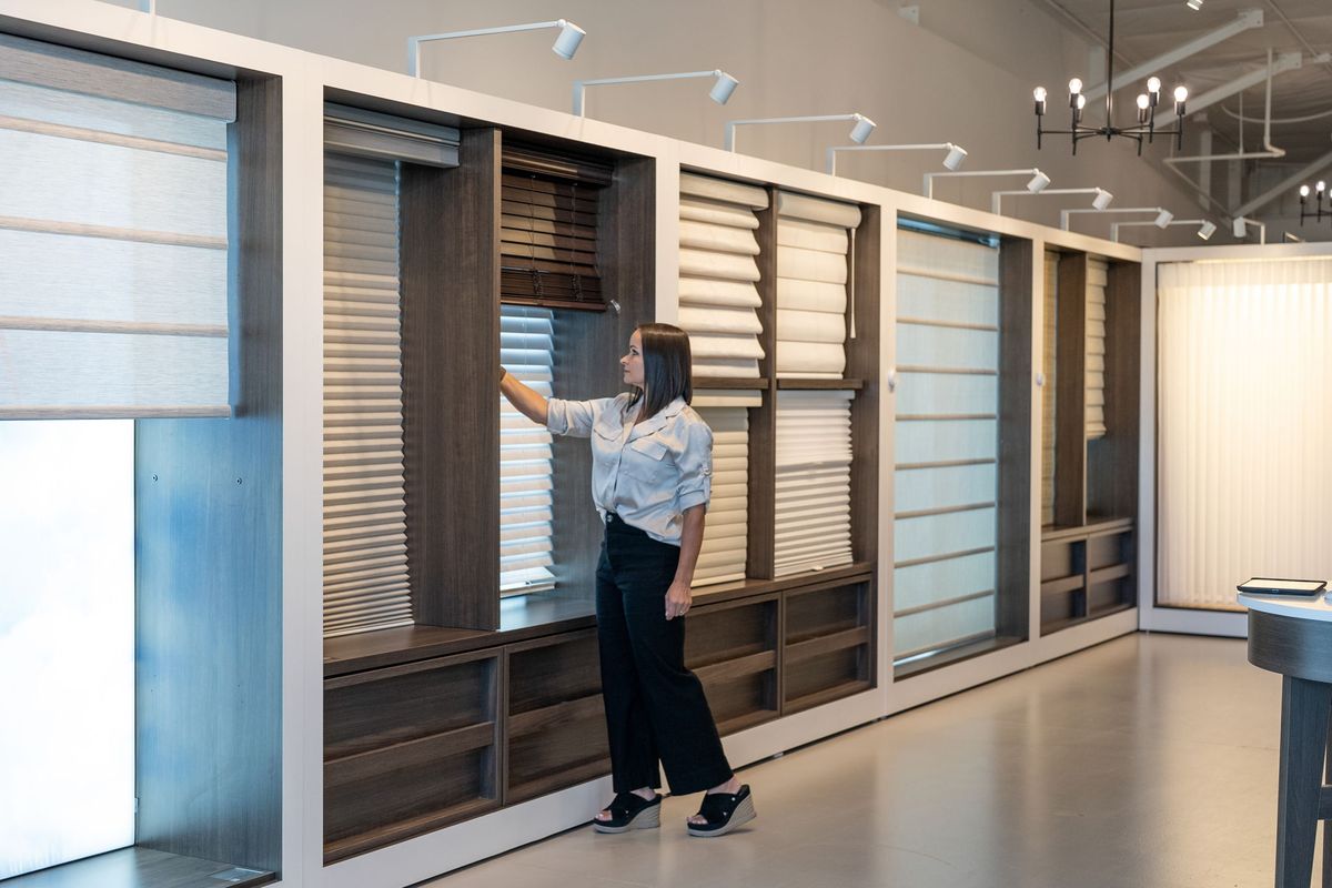 Carly Carr looks at some the window covering offerings available at Spokane Blinds. (Courtesy Spokane Blinds)