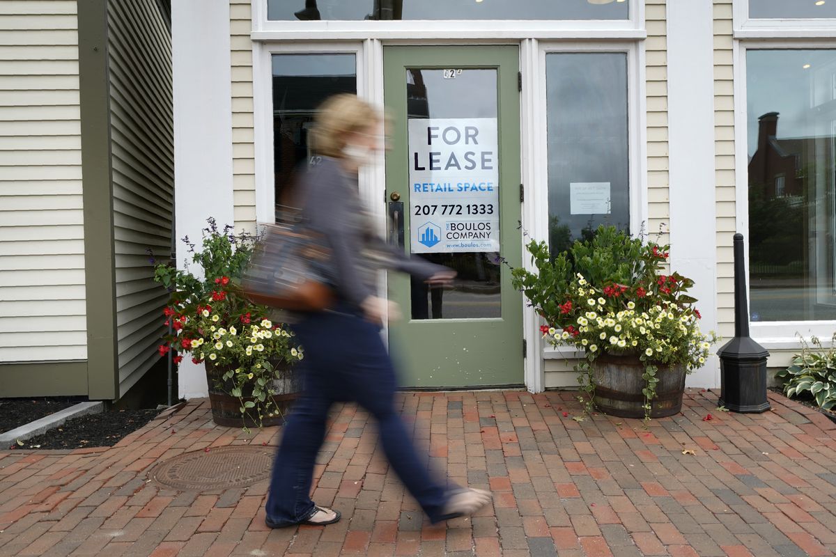 In this Sept. 2, 2020, file photo, a shopper walks by one of several vacant retail spaces among the outlet shops in Freeport, Maine. The U.S. unemployment rate dropped to 7.9% in September, but hiring is slowing and many Americans have given up looking for work, the government said Friday, Oct. 2, in the final jobs report before the voters decide whether to give President Donald Trump another term. (Robert F. Bukaty)