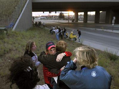 Elsie Long, wearing a Costco hat, is joined Tuesday by friends and co-workers of her grandson Robb Long, who was killed three years ago by a drunken driver at the Sprague Avenue freeway overpass, shown in the background. (CHRISTOPHER ANDERSON / The Spokesman-Review)
