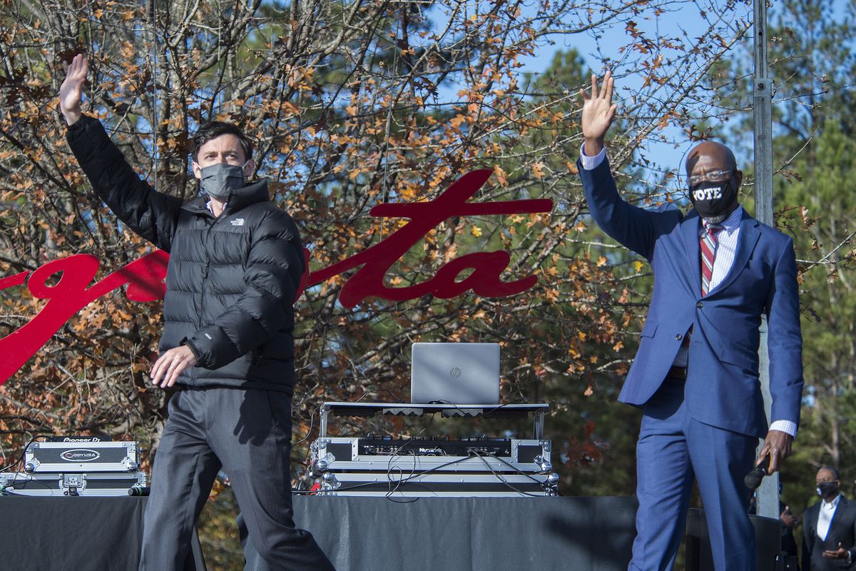 Jon Ossoff, left, and Raphael Warnock wave to the crowd during a campaign rally in Augusta, Ga., Monday, Jan. 4, 2021. Democrats Ossoff and Warnock are challenging incumbent Republican Senators David Perdue and Kelly Loeffler in a runoff election on Jan. 5.  (Michael Holahan)