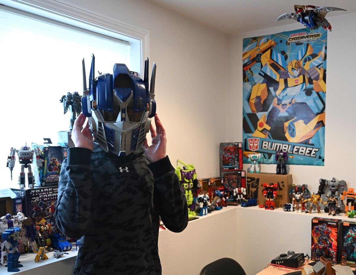 Avid Transformers toy collector Isaac Sims, 13, dons a voice-changing helmet from his collection. (Jesse Tinsley/The Spokesman-Review)