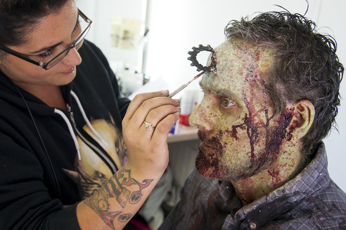 Special effects make-up artist Corinne Foster applies fake blood to a sprocket wound on Sean Dunn, a zombie extra on “Z Nation.” Thirteen episodes of the Syfy Network television series about a zombie apocalypse will be produced in Spokane. (Colin Mulvany)
