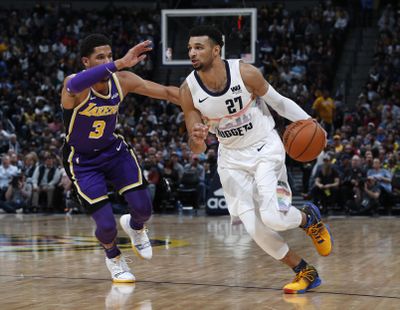 Denver Nuggets guard Jamal Murray drives past Los Angeles Lakers guard Josh Hart during the second half Tuesday night in Denver. The Nuggets won 117-85, their biggest ever victory over the Lakers. (David Zalubowski / Associated Press)