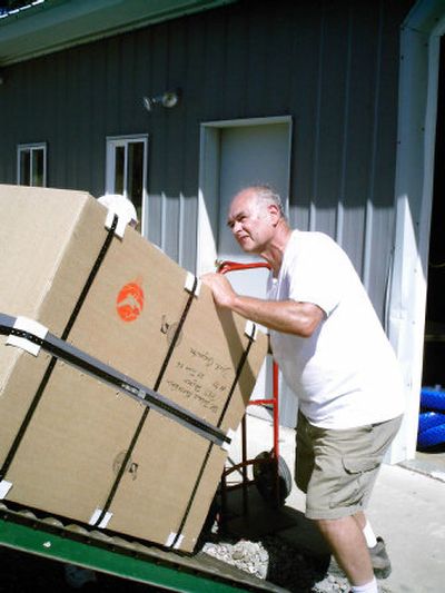 
Dick Carpenter, founder of the volunteer Inland Northwest PET Project, loads one of the 50 rugged-terrain, hand-cranked wheelchairs built here for disabled individuals in underdeveloped nations. 
 (Photo courtesy of Julie Wasson / The Spokesman-Review)