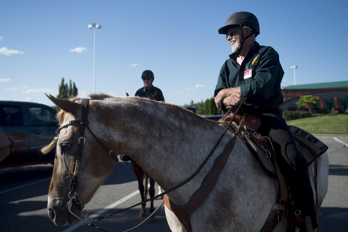 Ed Ross grins as he sits atop his horse Chieftain before setting out on patrol on Thursday, July 14, 2016, at Spokane Valley Mall in Spokane Valley, Wash. Ross and Chieftain are part of SCOPE’s mounted patrol unit which roves the parking lot at the mall. (Tyler Tjomsland / The Spokesman-Review)