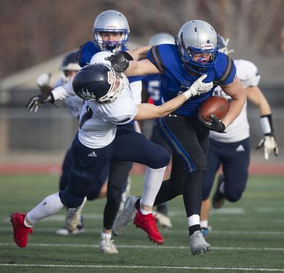 La Salle’s Ryan Kershaw, right, tries to shed a Lynden Christian tackler during Saturday’s State 1A quarterfinal at Zaepfel Stadium. (Yakima Herald-Republic)