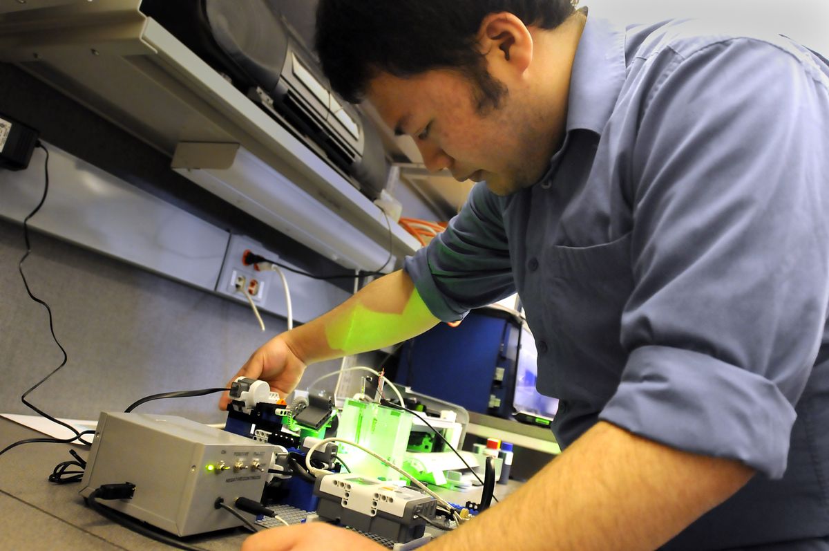 Thanh Do, a senior chemistry major at Gonzaga University, adjusts a piece of hardware that uses light to try to free hydrogen from water Monday. The project’s goal is to produce hydrogen from water using various catalysts and light.   (Photos by JESSE TINSLEY / The Spokesman-Review)