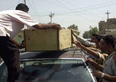 
Relatives take a body for burial after clashes with coalition forces in Sadr City left at least 35 Iraqis dead in Baghdad on Tuesday.
 (Associated Press / The Spokesman-Review)