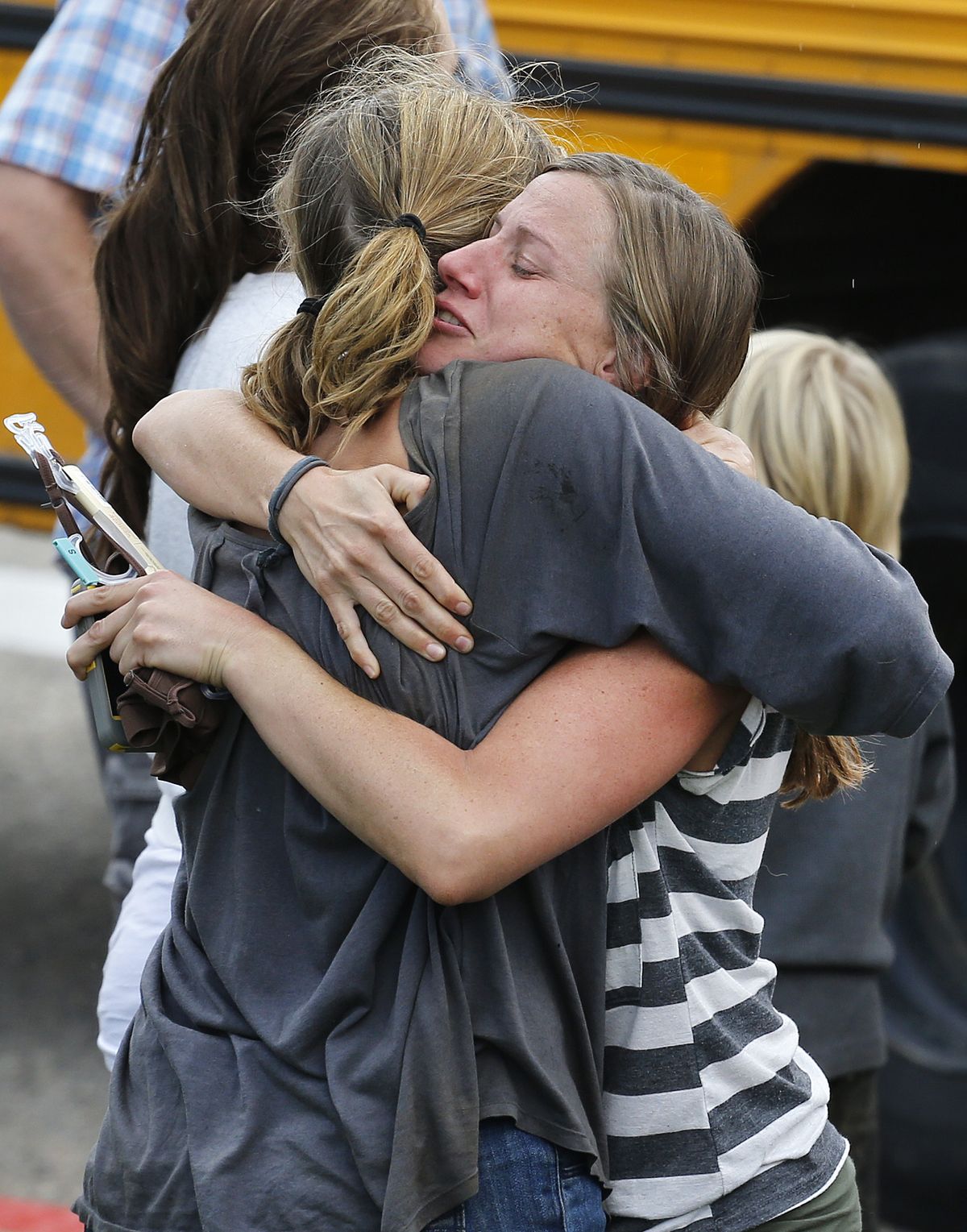 Evacuees embrace Saturday at a drop-off point for those rescued after days of flooding, at a high school in Niwot, Colo. (Associated Press)