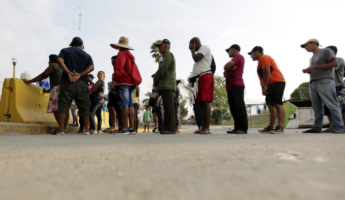 Migrants seeking asylum in the United States line up April 30, 2019, for a meal provided by volunteers near the international bridge in Matamoros, Mexico. The U.S. government will expand its policy requiring asylum seekers to wait outside the country in one of Mexico’s most dangerous cities. According to officials for two congressional Democrats, the Department of Homeland Security says it will implement its “Migrant Protection Protocols” in Brownsville, Texas, across the border from Matamoros, Mexico. Matamoros is in Mexico’s Tamaulipas state, which the U.S. government warns citizens not to visit due to violence and kidnappings. (Eric Gay / Associated Press)