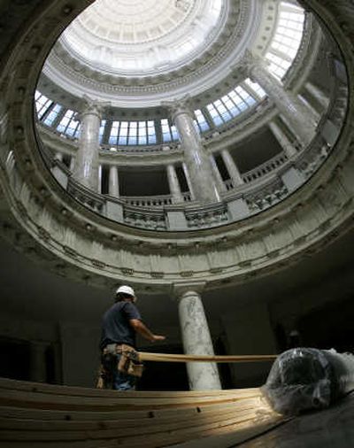 
Workers carry boards used to protect fragile marble floors from construction debris through the Capitol Rotunda on Friday. Associated Press
 (Associated Press / The Spokesman-Review)
