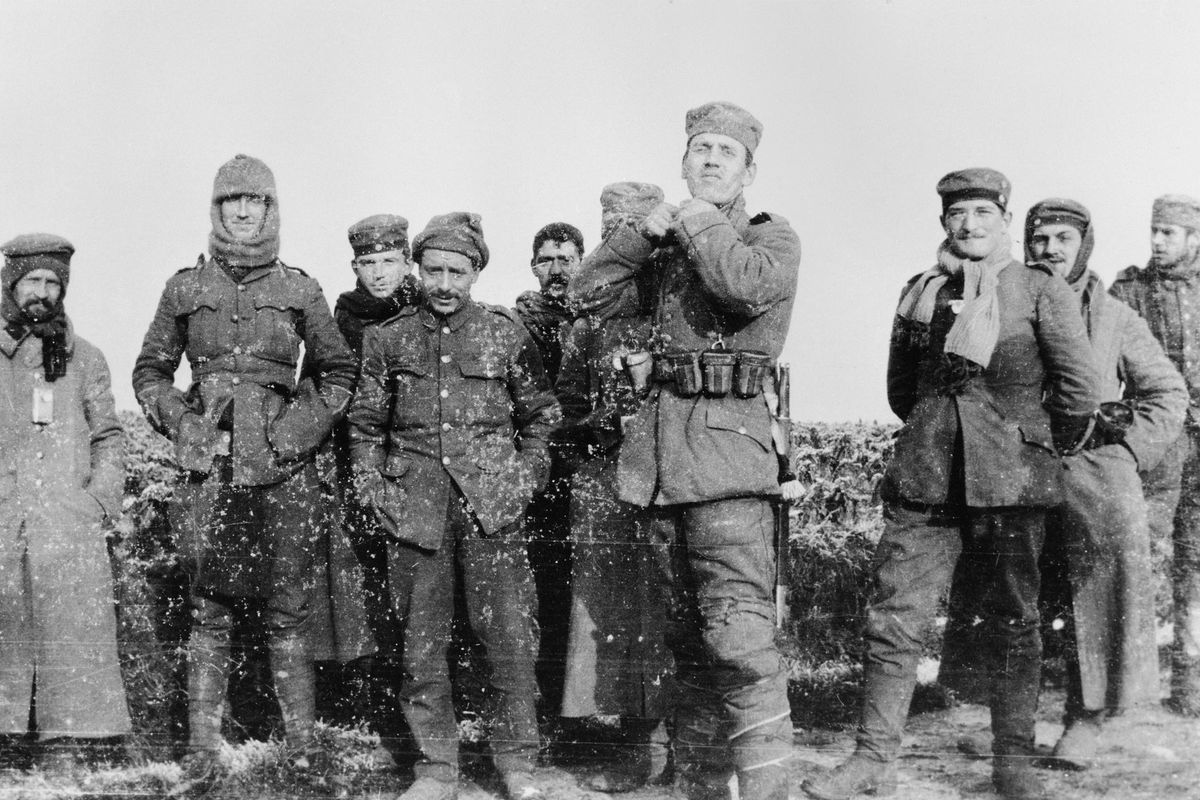 In this image from the Imperial War Museum, World War I German and British soldiers mingle on the battlefield near Ploegsteert, Belgium, on Dec. 25, 1914. Eyewitness accounts said the soldiers also played a game of soccer.