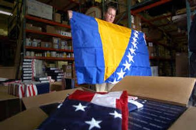 
Eric Penney holds the flag of Bosnia that he will be shipping to the Athens Olympics from his Spokane business, Murray Supply. 
 (Christopher Anderson/ / The Spokesman-Review)