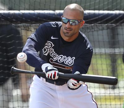 Atlanta Braves outfielder Nick Markakis lays down a bunt during spring training baseball practice in North Port, Fla., Tuesday, Feb. 18, 2020. (Curtis Compton / Atlanta Journal-Constitution via AP)