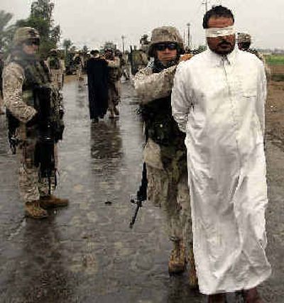 
U.S. Marines of the 1st Division arrest Iraqi council chairman Taha Rasheed following a raid in the Abu Ghraib district of Baghdad on Tuesday. The Marines arrested the city council chairman of Nasar Wa Sulaan and other council members following the raid. 
 (Associated Press / The Spokesman-Review)