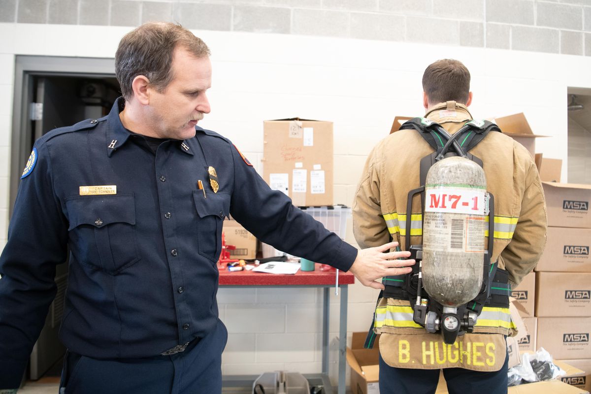 Spokane Valley Fire Capt. Joe Schindler points out some of the features in the new breathing apparatus soon to be used by the Spokane Valley Fire firefighters Wednesday, Dec. 26, 2018, at Spokane Valley Fires Liberty Lake station. Firefighter paramedic Bryce Hughes is wearing the pack. (Jesse Tinsley / The Spokesman-Review)