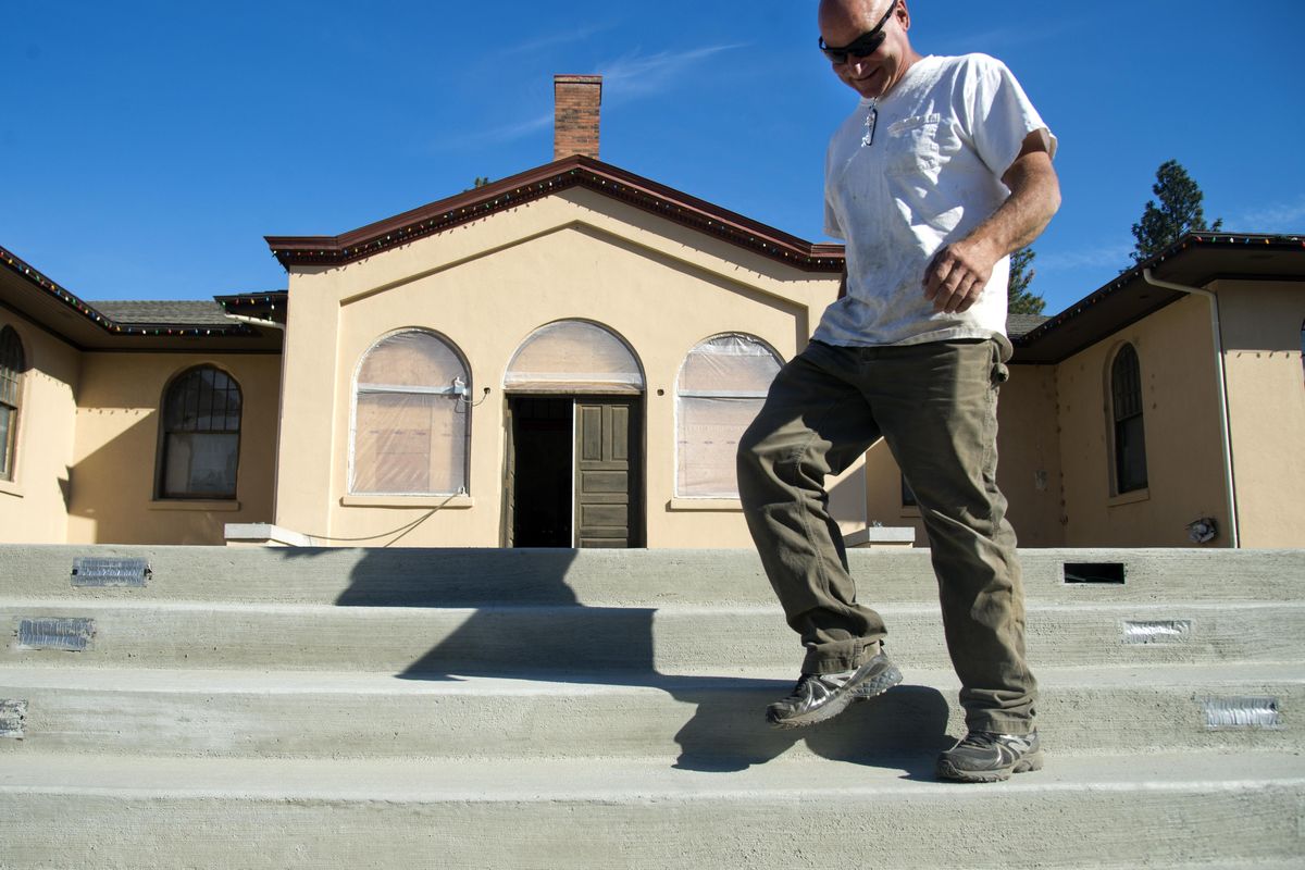 Contractor Kurt Holbart of Holby Construction walks down the new concrete steps on Oct. 5 in front of the old Lowell School building, which is undergoing restoration by his crew in Vinegar Flats. (Jesse Tinsley / The Spokesman-Review)