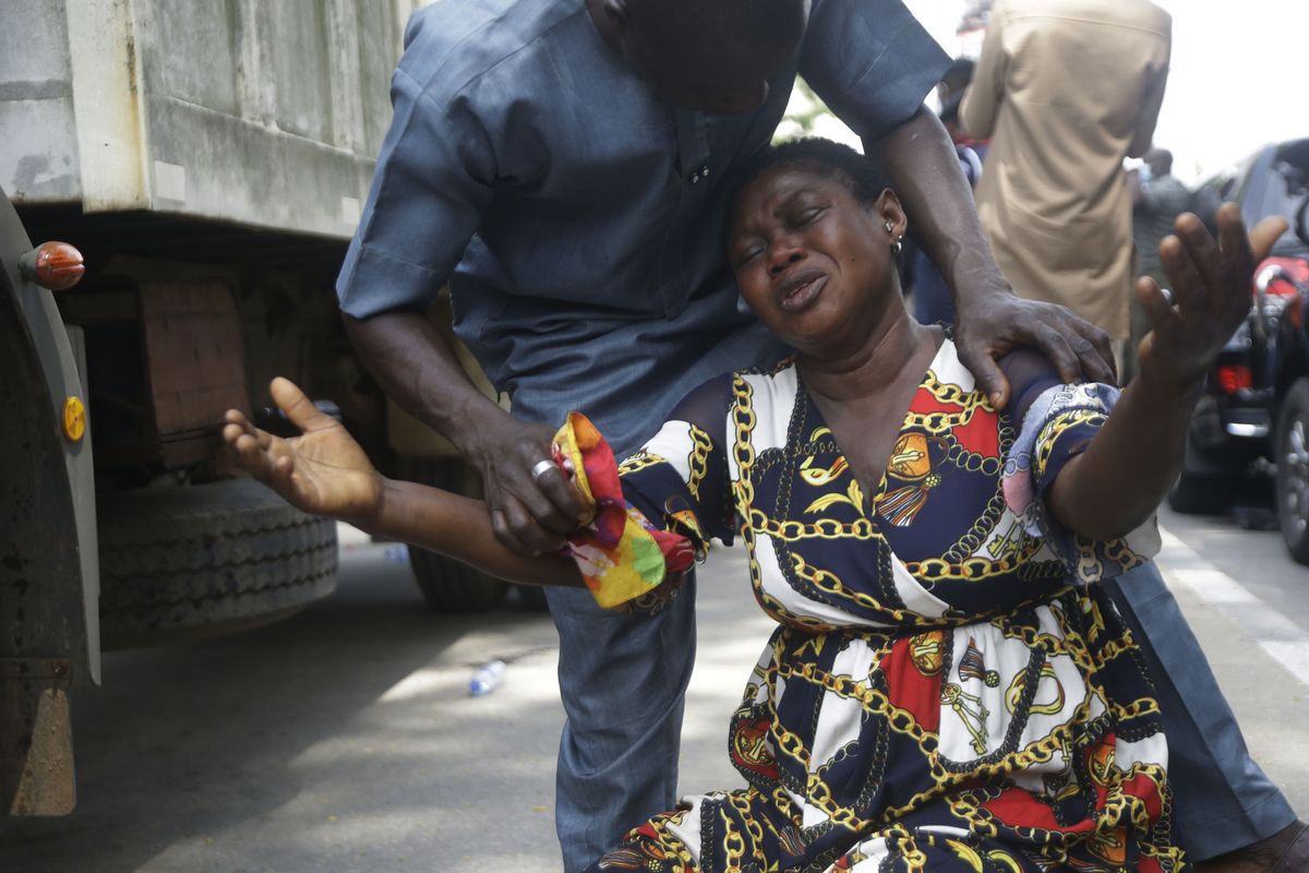 A relative of a missing person cries at the site of a collapsed 21-story apartment building under construction in Lagos, Nigeria, Wednesday, Nov. 3, 2021. The number of bodies recovered at the site of the building that collapsed in Nigeria has risen to 21, the Lagos governor said Wednesday, admitting that the search and rescue mission is "still a very difficult, a very long procedure." On day three of the search operation at the Ikoyi area of Lagos, excavators combed through the pile of debris while oxygen and water were intermittently pumped into the rubble as the search continues.  (Sunday Alamba)