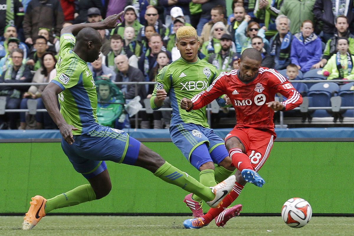 Seattle’s Djimi Traore, left, and DeAndre Yedlin, center, can’t stop a first-half goal by Toronto