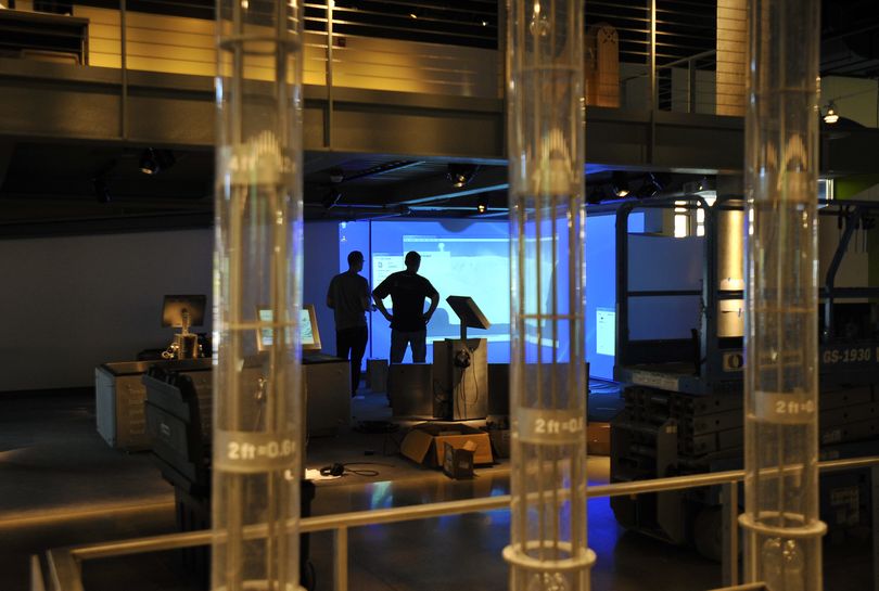 Christian Bannister and Shawn Sessions work on the installation of an exhibit at the new Mobius Science Center in downtown Spokane. (Dan Pelle)