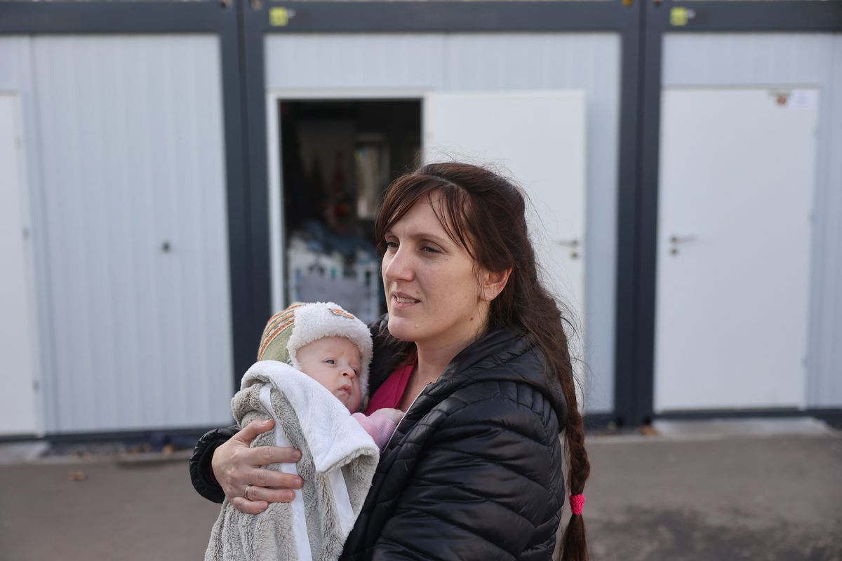 Alina Pidchenko with her three-month-old son in front of their single room in a camp of prefabricated housing for displaced Ukrainians near Lviv on Jan. 2. MUST CREDIT: Photo for The Washington Post by Roman Baluk  (Roman Baluk/For The Washington Post)