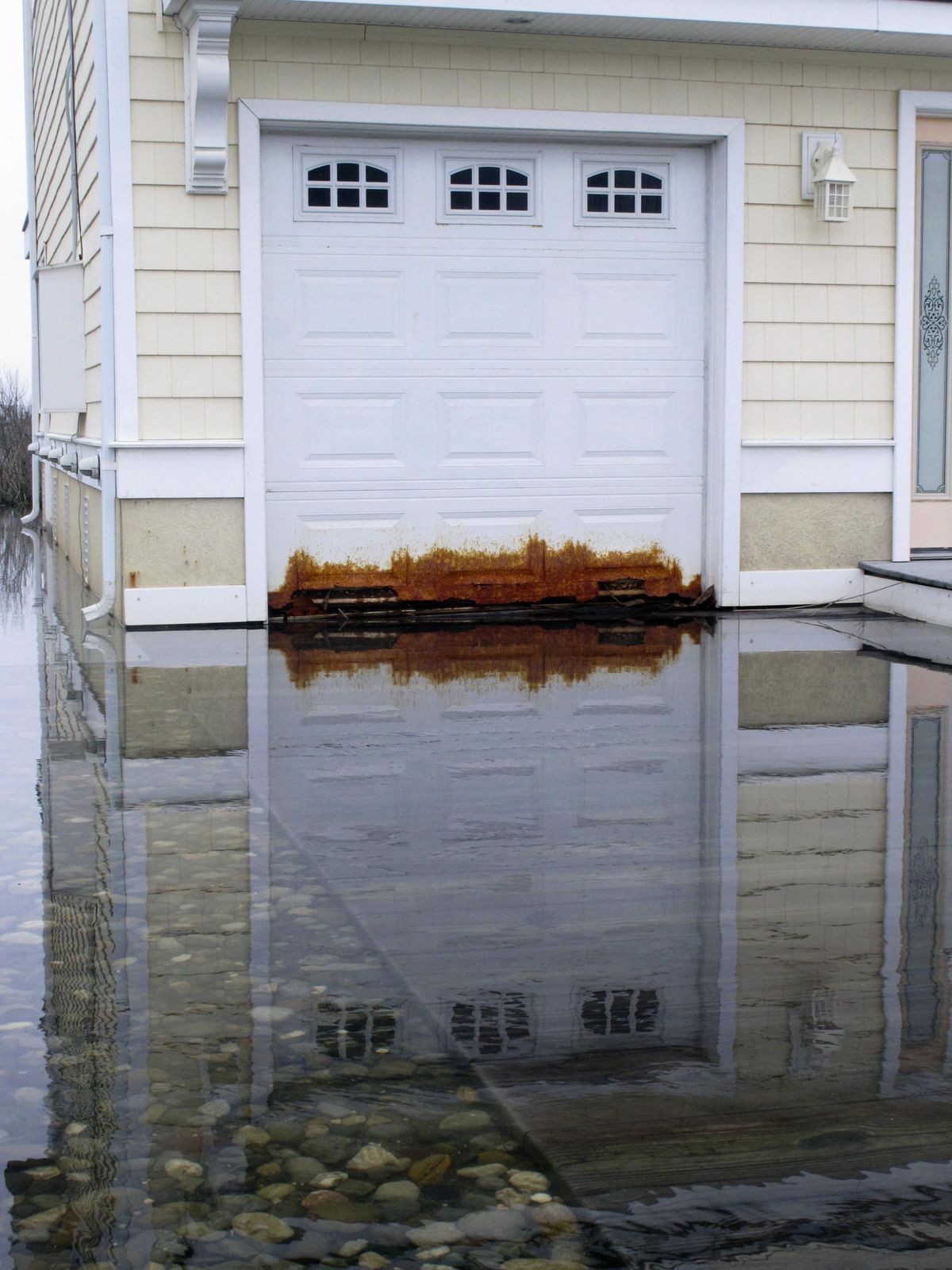 This April 26, 2017 photo shows a garage door on a home in Ocean City on the edge of a back bay that floods regularly, and has rusted the metal door. Scientists and people living in back-bay areas behind barrier islands say flooding is increasing, even as the problem gets less attention and money than flooding along the ocean. (Wayne Parry / Associated Press)