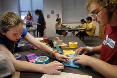 
Lewis and Clark High School senior Katy Timm helps fellow LC student Rocky Botner make a wallet out of duct tape during a workshop at the Spokane Public Library's Eastside branch. 
 (Holly Pickett / The Spokesman-Review)