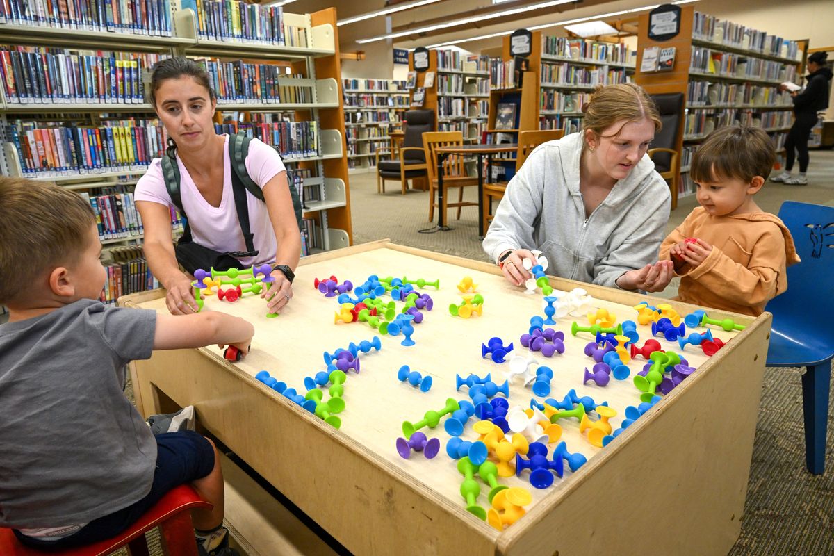 Janie Ortega and her son Wyatt, 2, left, and Liza Lee and her son Daniel, 2, right, play at a toy table in the Moran Prairie Library on Friday after attending a story time. The Spokane County Library system will have a levy vote on Aug. 4 to restore the regular property tax rate that funds daily operations and maintenance.  (Jesse Tinsley/THE SPOKESMAN-REVIEW)