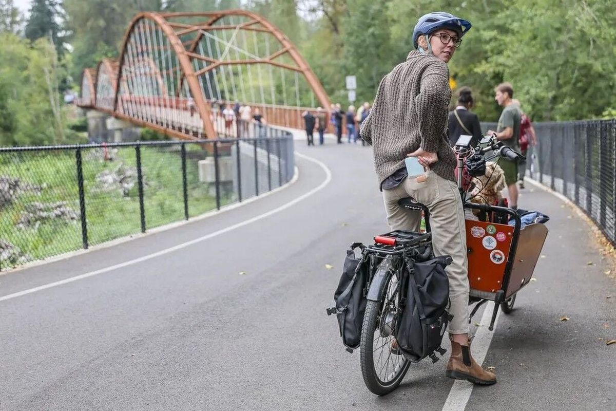 Bella McLaws of Enumclaw gets on her bike to cross the Foothills Trail bridge in Buckley. “We’re really two independent communities, but this closure has proved our dependency on each other,” she said. (Seattle Times)