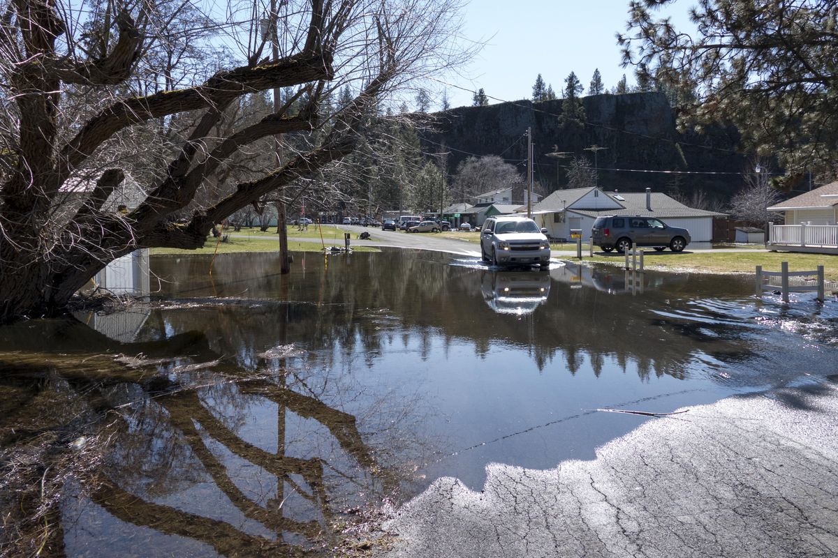 Water flows across Weisman Road from a slough into Williams Lake, Sunday, Mar. 19, 2017, a few inches higher than it was last week. (Jesse Tinsley / The Spokesman-Review)