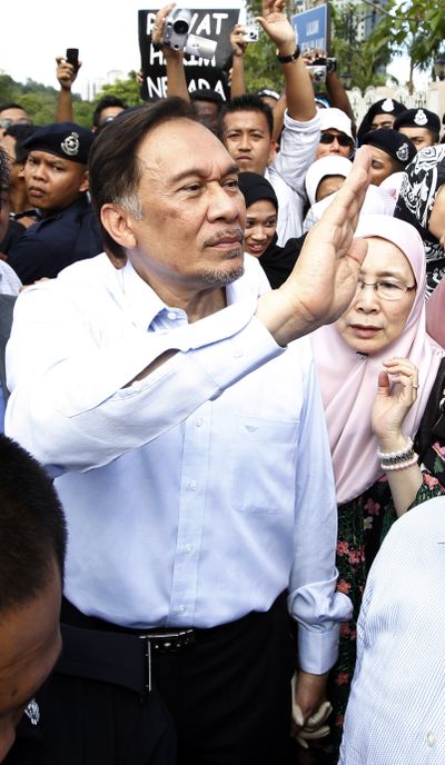 Anwar Ibrahim waves to supporters today as he leaves Malaysia’s High Court, where he was acquitted of sodomy. (Associated Press)