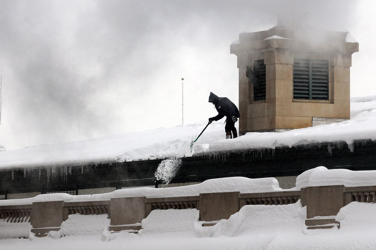 A postal employee shovels snow from the roof of the downtown Spokane Post Office Wednesday, December 24, 2008.   Five to nine inches of new snow is expected by Christmas Day. (Liz Kishimoto / The Spokesman-Review)