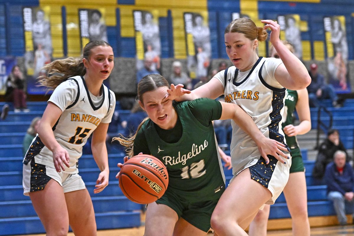 Ridgeline’s Grace Sheridan, center, rebounds the ball against Mead’s Ellie Thornton during a Greater Spokane League game on Tuesday at Mead High School in Mead.  (James Snook)