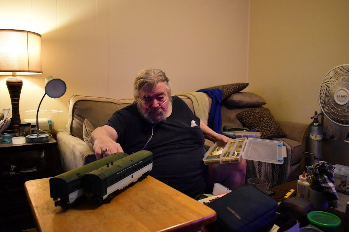 Vietnam veteran Glen Clemons pulls model trains out of a storage box in the living room of his St. John home. Clemons has several different gauges, or sizes, of trains in his collection.  (Emma Ledbetter/For The Spokesman-Review)