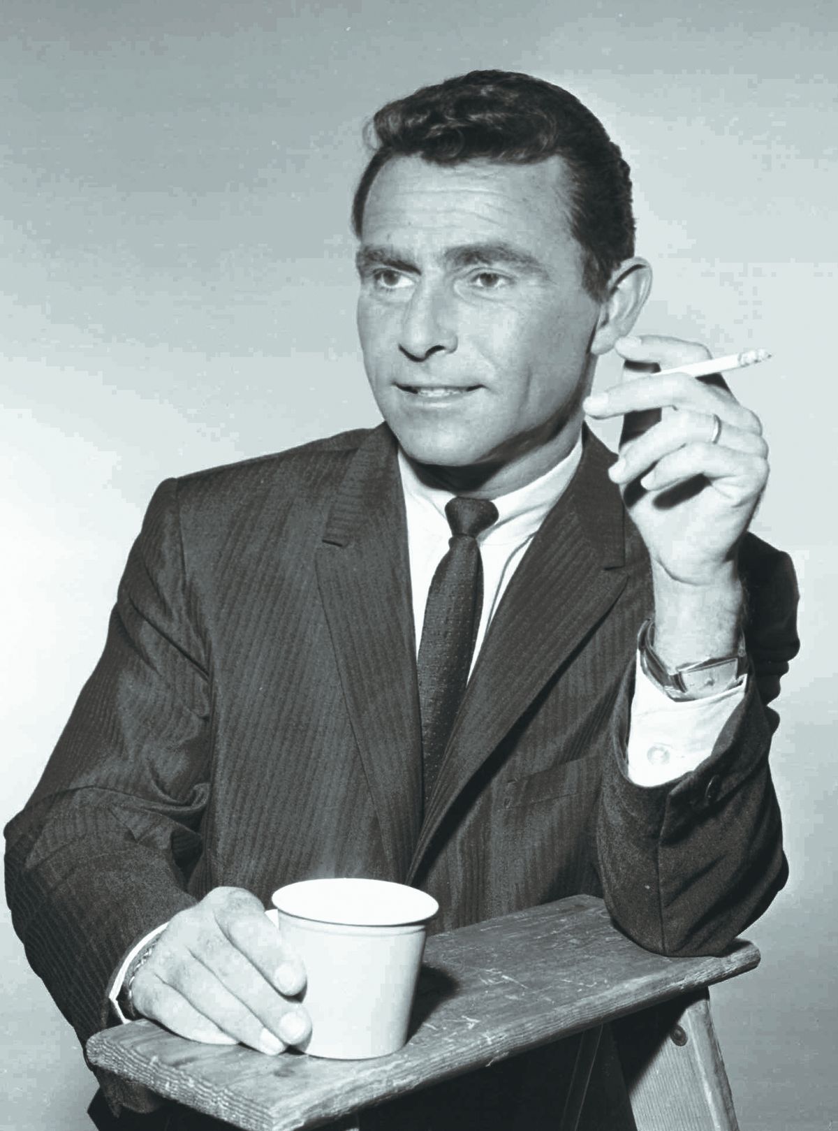 Rod Serling pauses for a cigarette and coffee between scenes during filming of “The Twilight Zone” in this 1961 file photo.  (Associated Press)