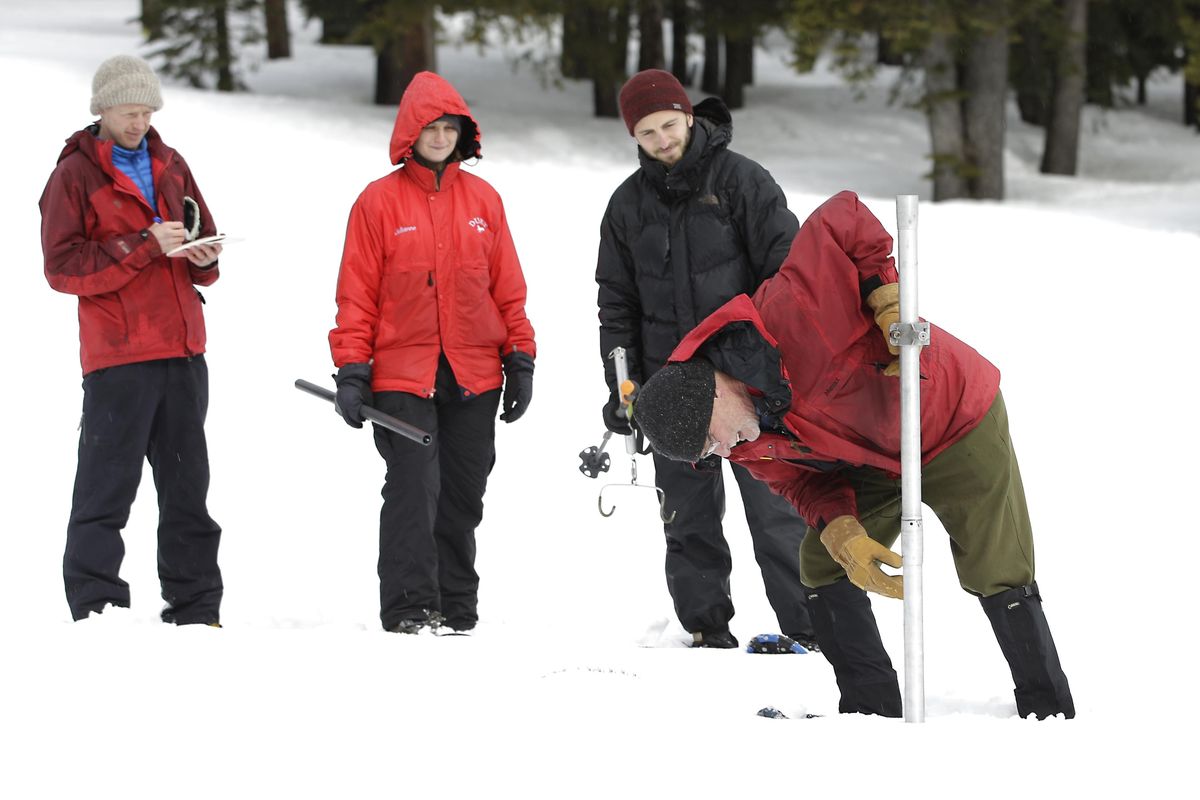 Frank Gehrke, right, chief of the California Cooperative Snow Surveys Program for the Department of Water Resources, checks the depth of the snowpack as he conducts the second manual snow survey of the season at Phillips Station, Thursday, Feb. 2, 2017, near Echo Summit, Calif. (Rich Pedroncelli / AP)