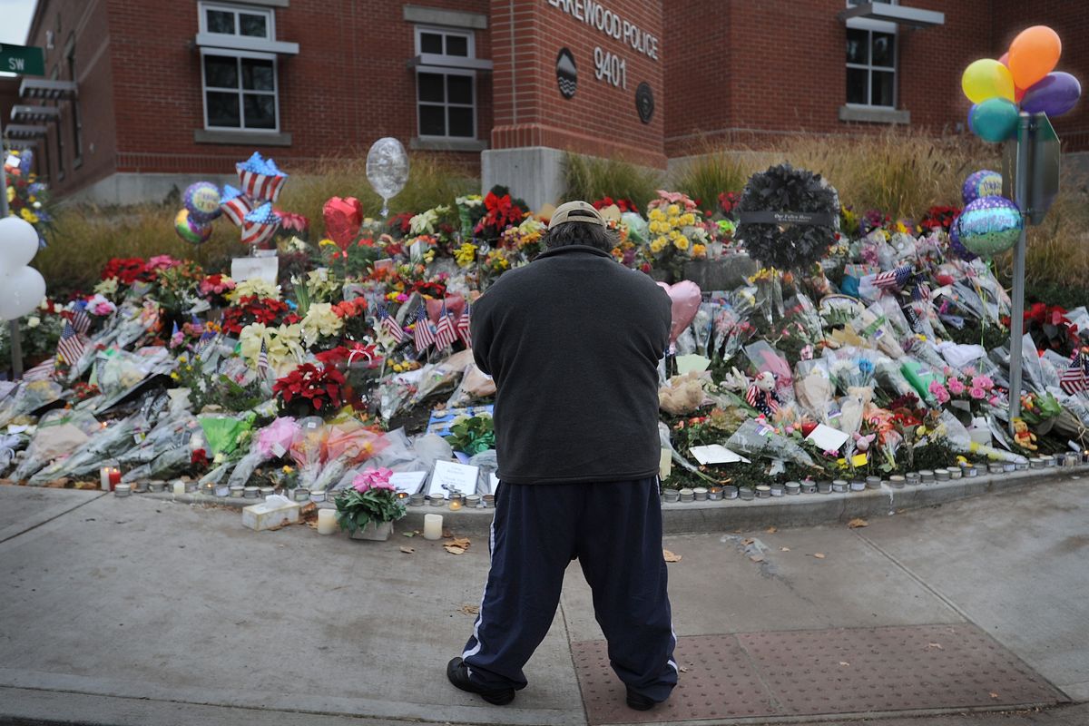 Dale Steinbach of Lakewood prays for the four slain police officers killed by a gunman at the Forza Coffee Company. Steinbach was paying his respects at the memorial site at the Lakewood Police Department on Monday, Nov. 30, 2009. (Lui Wong / The News Tribune)