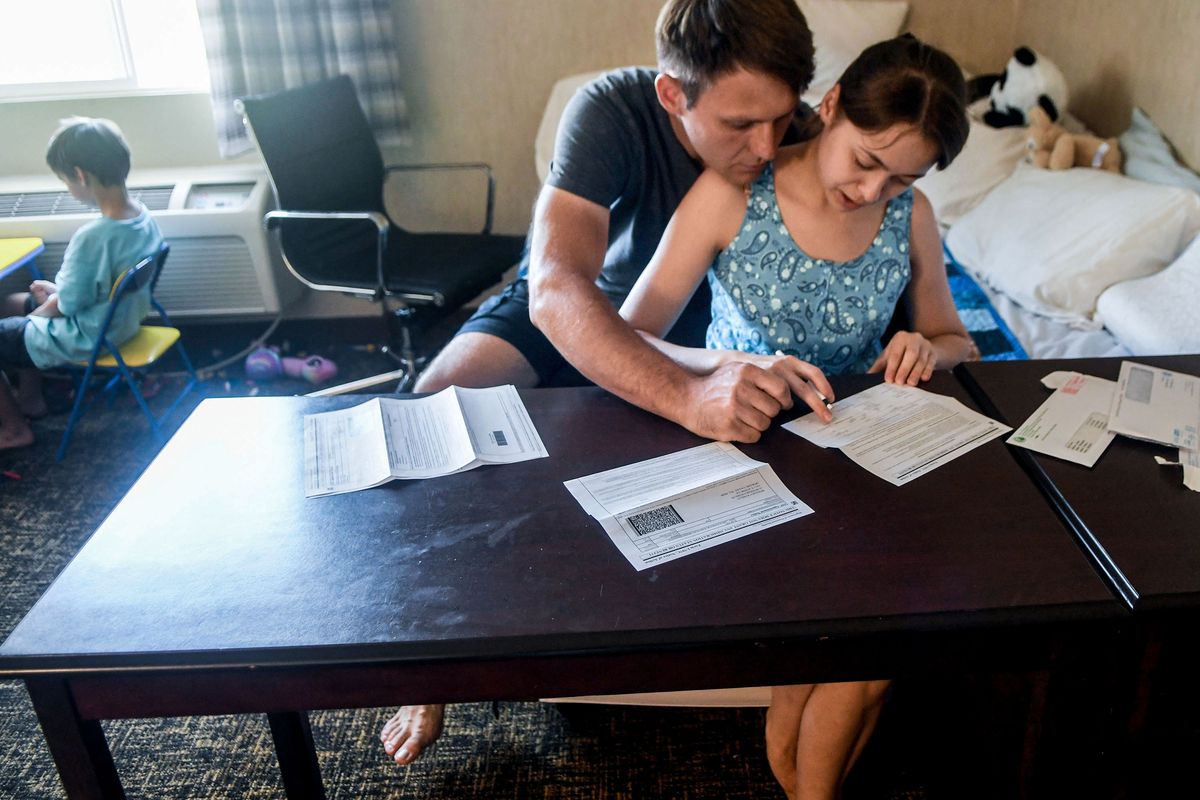 Mykhailo Kurilova and his wife, Anna, fill out documents for Temporary Protected Status on Aug. 2 while staying at the Thrive Center. (Kathy Plonka/The Spokesman-Review)