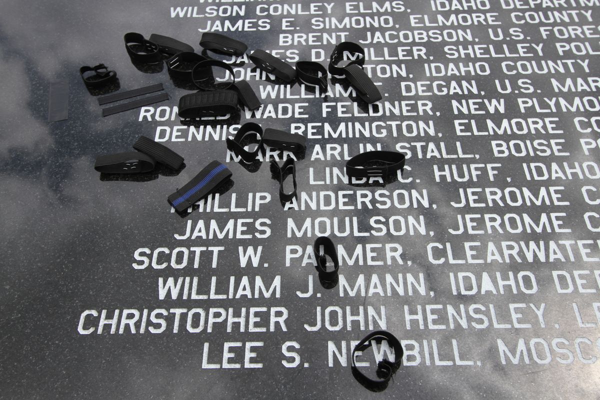 Police officer whose badges had been covered with black ribbons and cloth laid the covers on a memorial to fallen comrads this afternoon in a short but moving ceremony. (Photo: Duane Rasmussen)