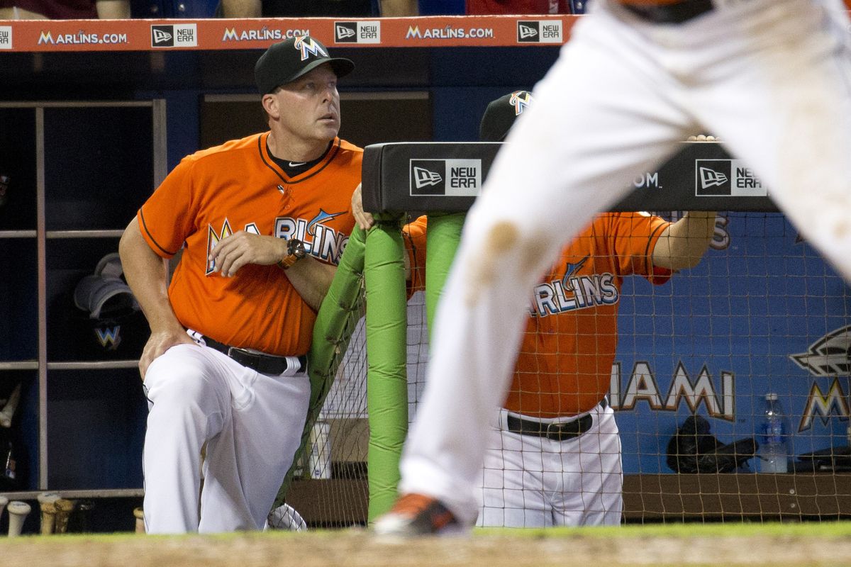 Mike Redmond stands in dugout during Sunday’s game in which the Marlins were nearly no-hit by Braves. (Associated Press)
