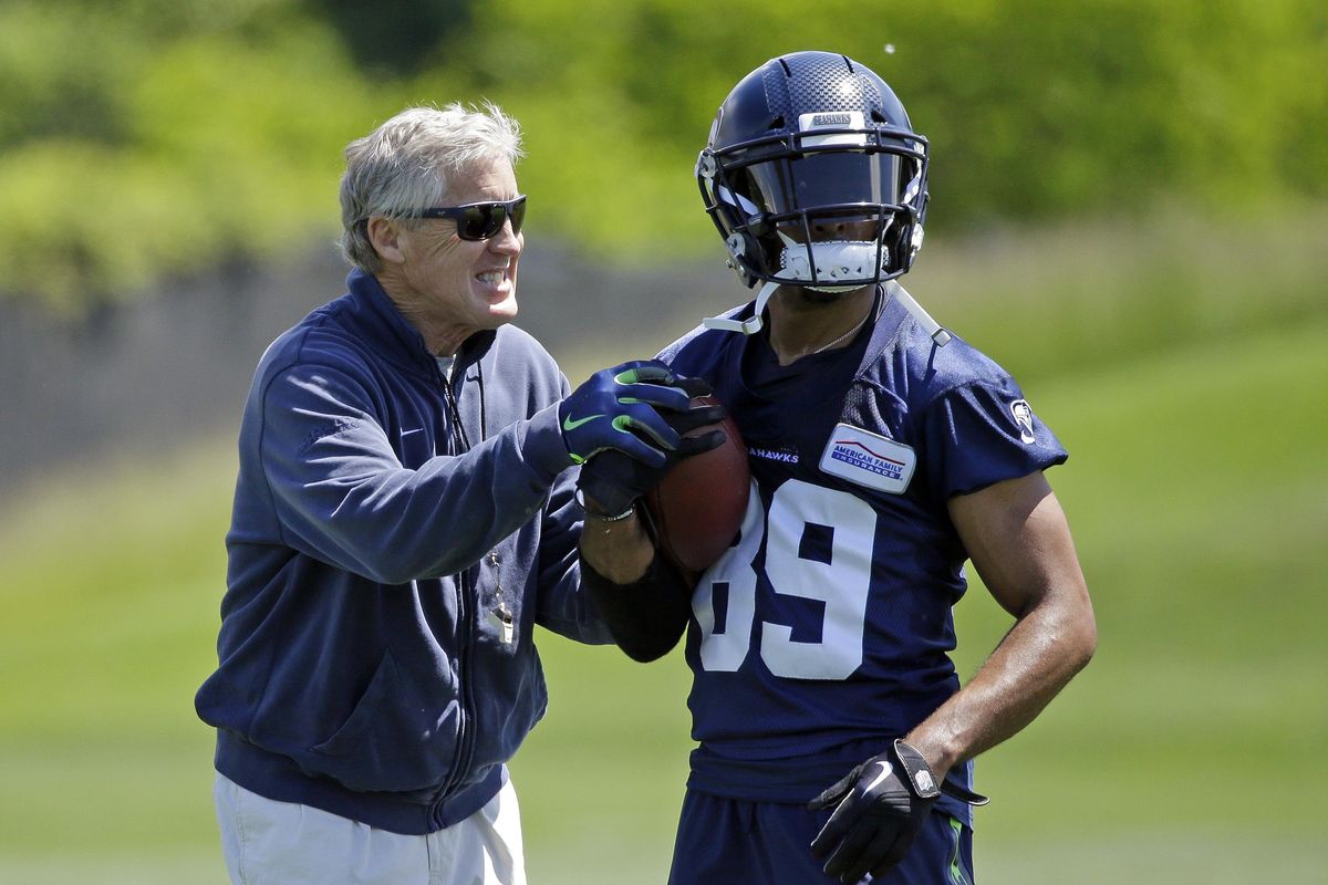 Seattle Seahawks head coach Pete Carroll, left, playfully grabs at the hands of wide receiver Doug Baldwin during NFL football practice, Friday, June 2, 2017, in Renton, Wash. (Ted S. Warren / Associated Press)