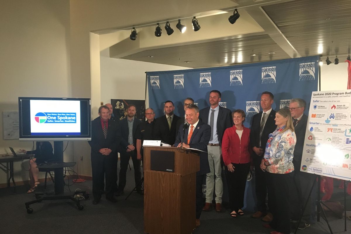 Mayor David Condon, center, presents his plan for city spending in 2020 at a news conference at Spokane City Hall on Thursday, Sept. 5, 2019. The initial budget proposal includes the hiring of 20 additional police personnel and retention of 30 grant-funded firefighters as envisioned in a property tax increase approved by voters in February, though Condon said he continued to have concerns about the longterm viability of that funding source for public safety. (Kip Hill / The Spokesman-Review)