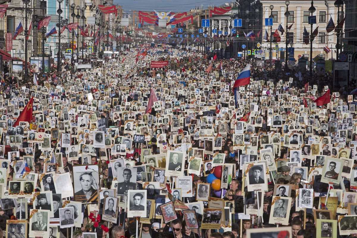 Local residents carry portraits of their ancestors, participants in World War II, as they celebrate the 70th anniversary of the defeat of the Nazis in World War II in St. Petersburg, Russia, on Saturday. About 100,000 people marched. (Associated Press)