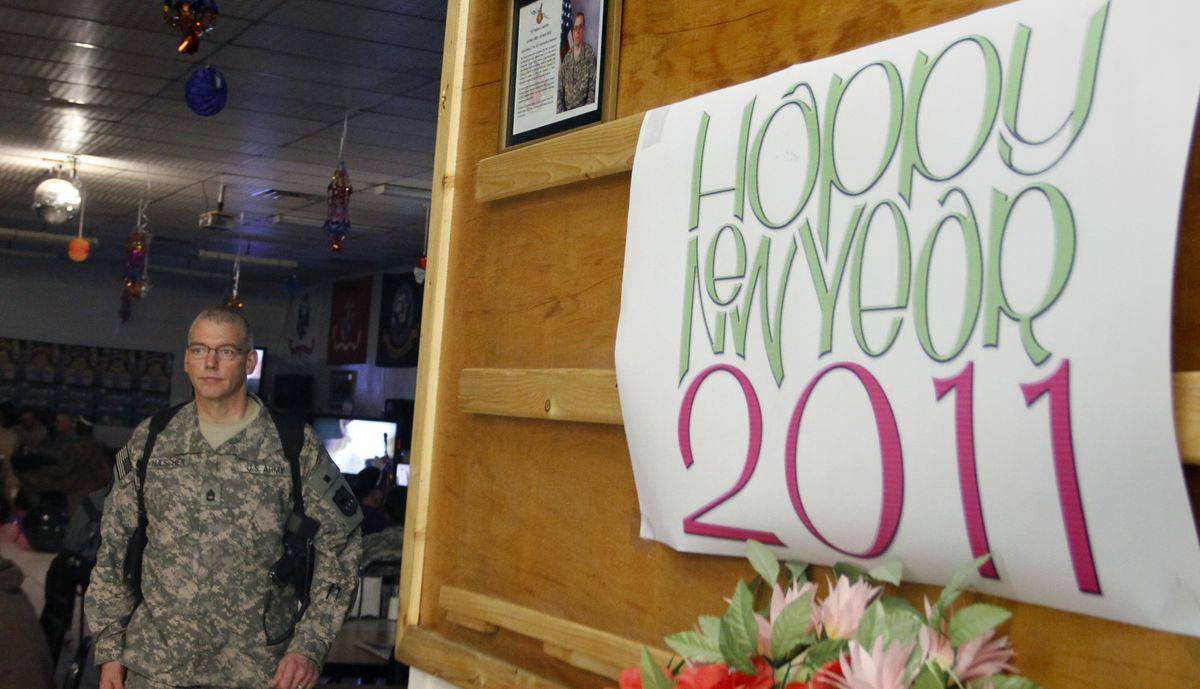  U.S. soldier Joe Hulscher walks  by a sign that reads “Happy New Year 2011” at Camp Phoenix in Kabul, Afghanistan, on Friday. 
