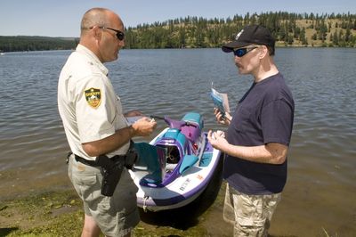 Spokane sheriff’s marine Deputy Thad Schultz gives personal watercraft owner Randy Brown a warning after Brown’s wife drove too close to another personal watercraft Tuesday on Long Lake. As the owner, Brown is responsible for the watercraft’s use. (Colin Mulvany / The Spokesman-Review)