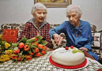 
Twins Gunhild Gaellstedt, left, and Siri Ingvarsson cut their birthday cake Friday in Stockholm, Sweden.
 (Associated Press / The Spokesman-Review)